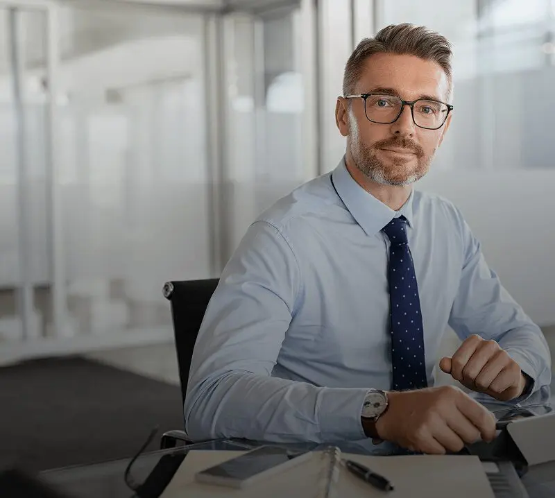 Businessman sitting at desk in office.
