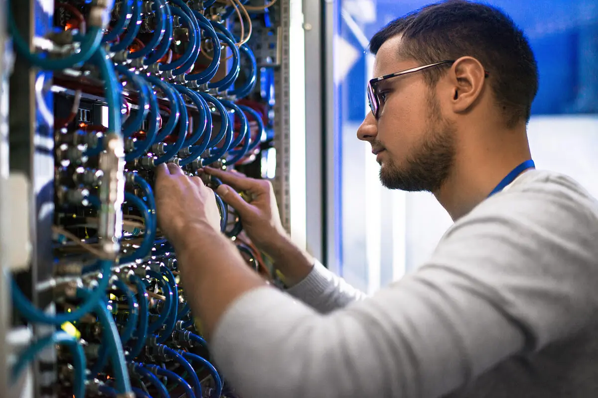 Technician working on server rack cables.