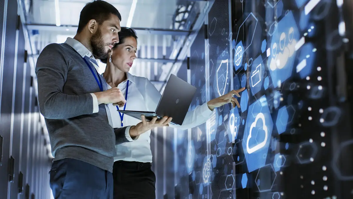 Two professionals analyzing digital cloud interface.