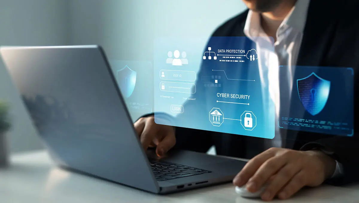 Person working on laptop with cybersecurity interface.